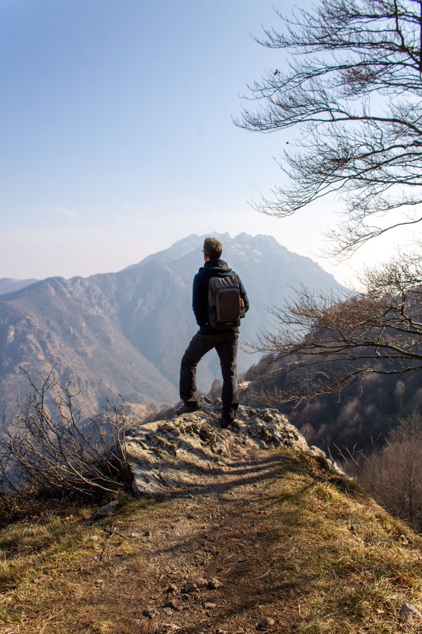 Man standing on mountain with no debt worries
